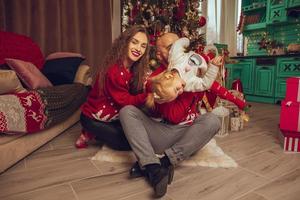 Cheerful young family with daughter celebrate Christmas and New year together photo