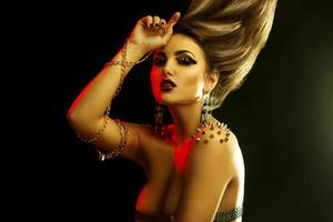 Portrait of sexual young fashionable woman with golden accessories and high straight hairstyle photo