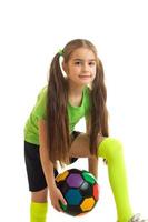 vertical de niña de la escuela con balón de fútbol de color en las manos foto