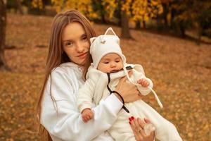 beautiful young mom with baby in autumn photo