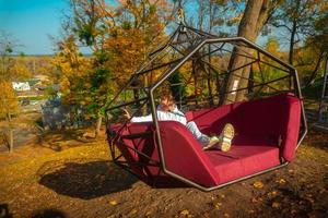 Girl rides on a swing over a cliff photo