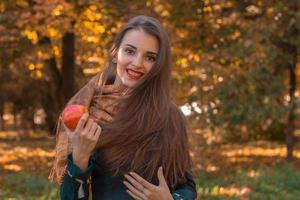 hermosa chica sonriendo y sosteniendo una manzana roja en la mano foto