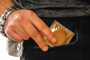 man gets a golden condom out of his pocket photo