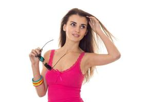 young cute girl in pink t-shirt keeps glasses and looks toward photo