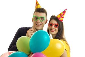 a close-up portrait of cheerful guy and girl in glasses and balloons photo