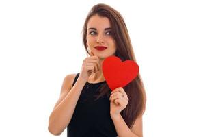 bella y elegante dama morena celebra el día de san valentín con corazón rojo aislado en fondo blanco foto