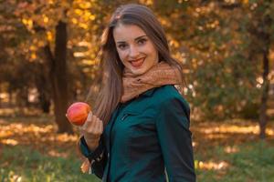 sweet girl stands on the street holding an Apple and smiles photo