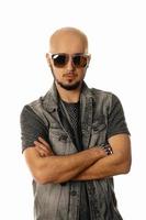 Serious unshaved man in sunglasses looking and posing on camera photo