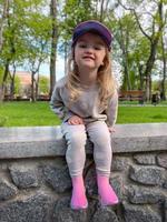 Funny little girl posing in the park and smiles photo