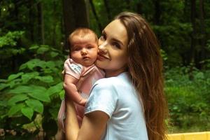 charming young mother with little baby girl in hands photo