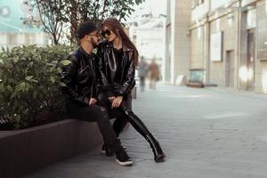 handsome couple in love looks at each others on the bench in the city photo