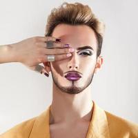 joven modelo gay con piel sana y maquillaje foto