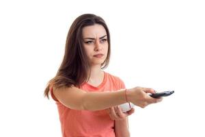 Serious girl with tv remote looking away photo