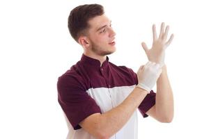 doctor in special clothes puts on white gloves hands isolated on white background photo