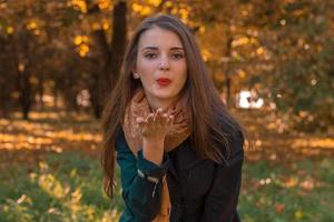 young girl with red lips sending a kiss in the Park photo