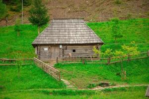 Old wooden house on a green hill photo