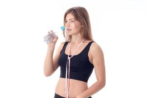 athletic girl holding a bottle and about to drink the water photo