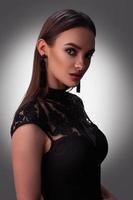 Sexy young lady in black dress in studio photo