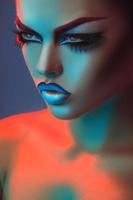 retrato de una hermosa mujer adulta con luces rojas y azules y maquillaje foto