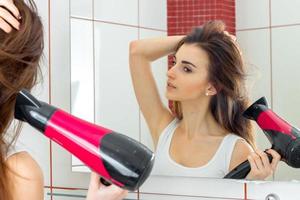 hermosa mujer en el baño se seca el cabello foto