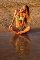 beautiful young girl in the sea at sunset photo