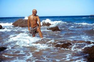 handsome young guy in the blue sea photo