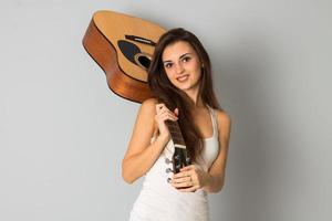 beautiful brunette woman with guitar in hands photo