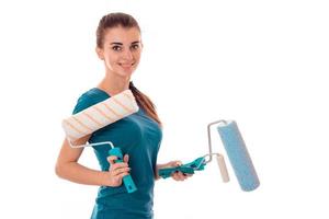 young cheerful builder girl in uniform makes renovation isolated on white background photo