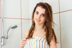 cute young girl with wet volosai in the soul looks straight and smiling photo