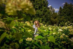 sexy young lady posing in the field flowers in dress with print photo