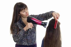 a female hairdresser combing her hair and dries a little girl closeup photo