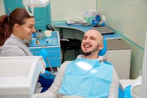 dentista divirtiéndose con el paciente durante el tratamiento foto