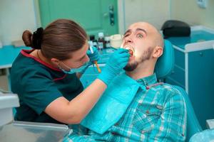 Photo dentist treating teeth to the patient