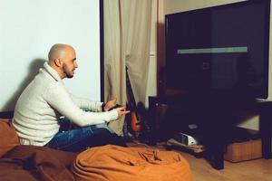 Elegant male playing computer games on tv photo