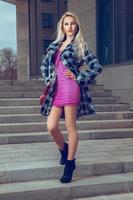 Slim young blonde fashion model with blue eyes posing outdoors photo