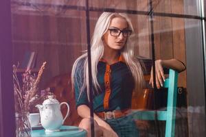 Sensual beauty blonde business woman in city caffee looking at window and thinking about something photo