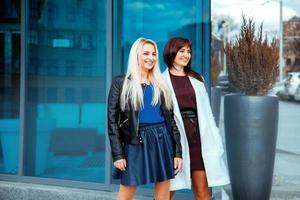 attractive happy ladies brunette and blonde looking away photo