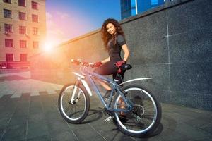 Chica joven de pelo rojo glamour en bicicleta foto