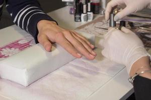 Manicurist is making manicure photo