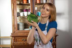 Girl chef with green cabbage in hands photo