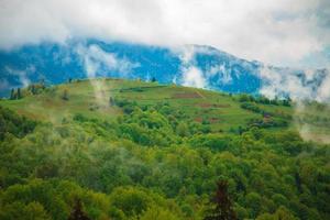 mountain landscape with clouds floating through the trees photo