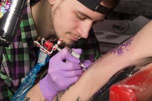 tatuador está haciendo tatoo foto