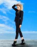 curly blonde business woman walks outdoors photo