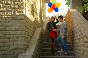 couple walks outdoors with balloons photo