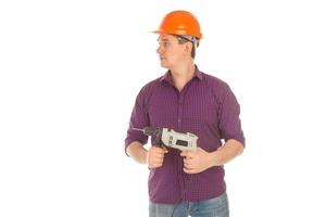 constructor masculino en casco y taladro en las manos foto