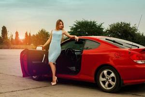 sexy young lady on high heels near a red car photo