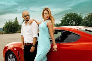 Gorgeous woman and handsome man with red sport car photo