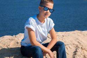 boy in sunglasses at the beach photo