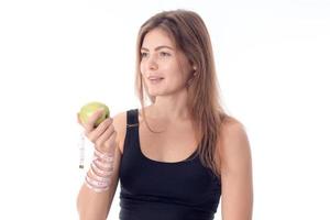 athletic girl standing sideways squeezing an apple in her hand photo