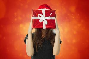 woman in santa hat with red gift photo